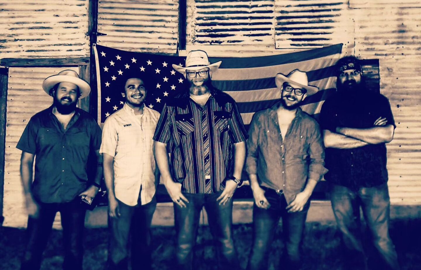 Band standing in front of an American flag