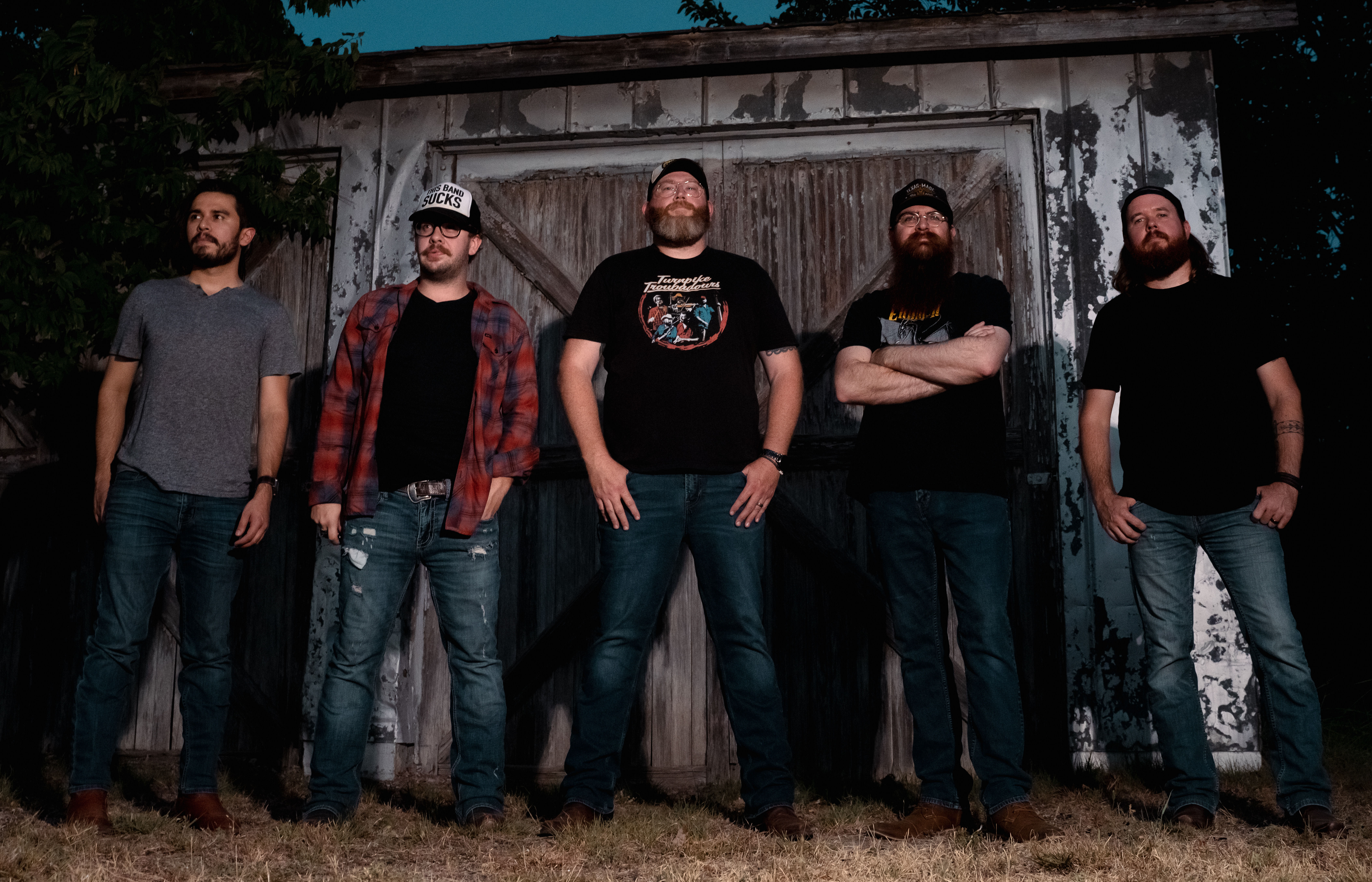 Band Standing In Front Of Barn Wearing Rock Shirts